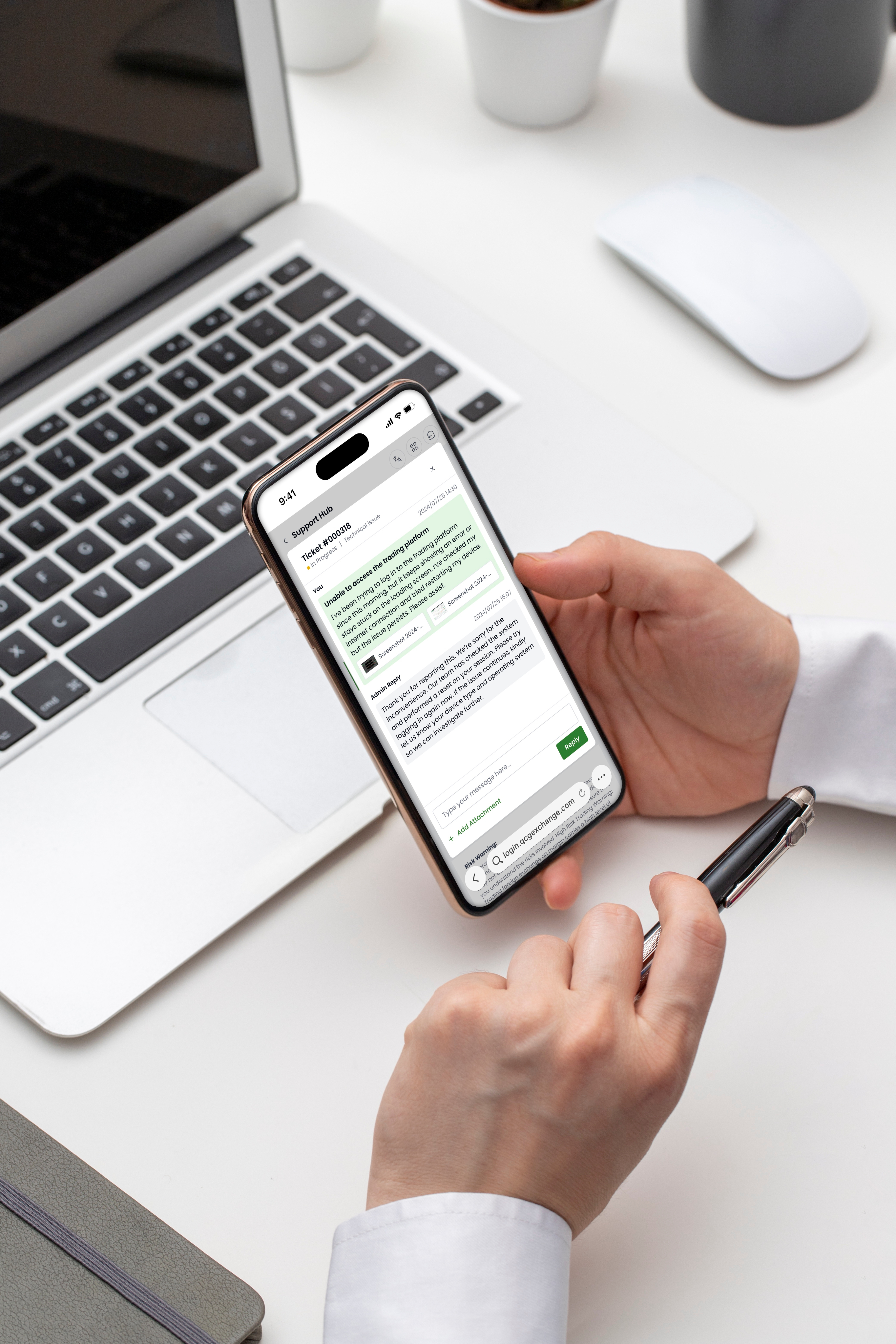 A person's hands holding a smartphone and a pen at a desk, with the phone displaying a 'Support Hub' chat interface regarding a technical issue with a trading platform.