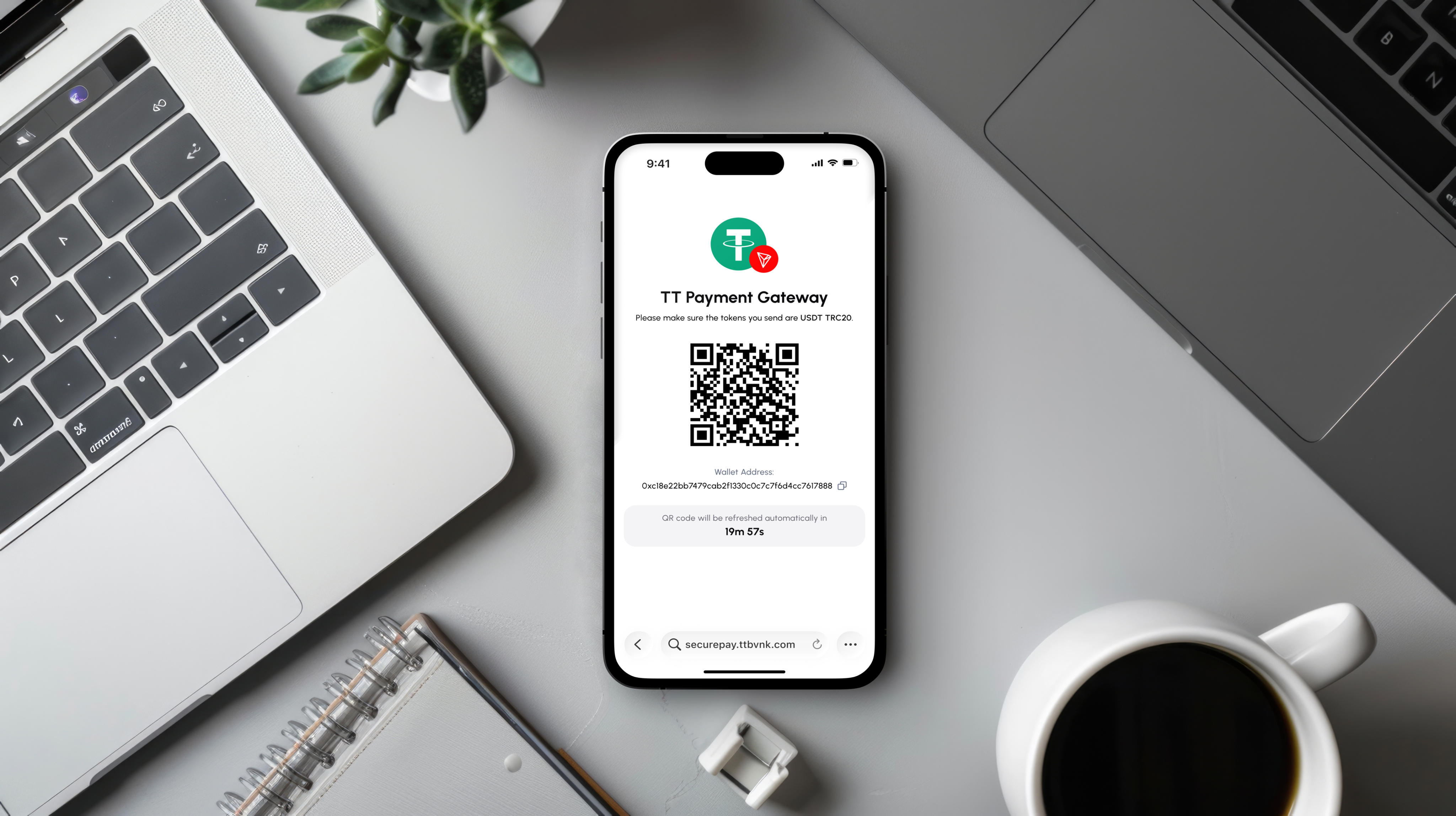 A top-down view of a smartphone on a desk showing a QR code for a 'TT Payment Gateway' deposit, placed between a laptop and a cup of coffee.